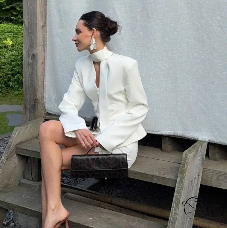 Elegant langry fashion white high-neck blouse with bell sleeves and black clutch bag in waist-tight blazer hip skirt two-piece set