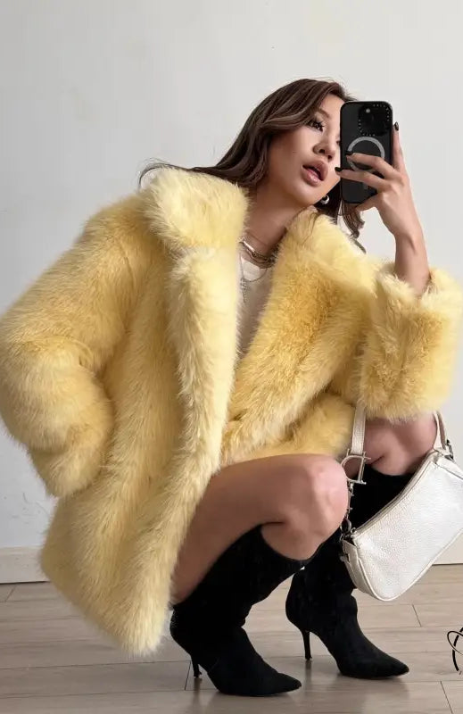 Yellow faux fur Langry coat with black heels and white handbag
