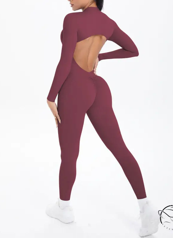 Maroon long sleeve yoga jumpsuit with back cutout and high-waisted leggings