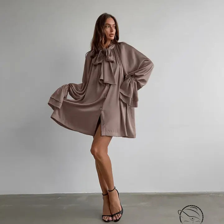 Elegant flowy taupe satin dress with oversized bow and billowing sleeves