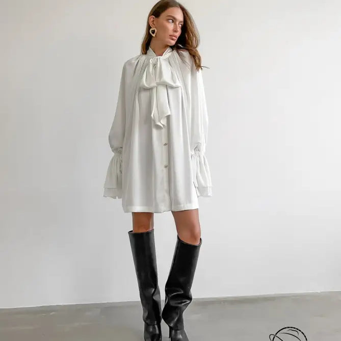Elegant satin dress with ruffled bow collar, long sleeves, and black boots