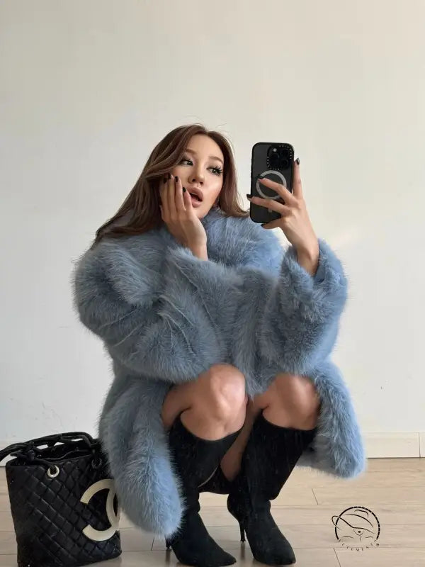 Mid-length Langry faux fur coat with blue fur, black trim, and high-heeled boots