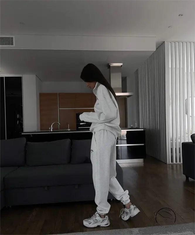 Woman in white tracksuit wearing autumn winter fleece lined half zipper sweater