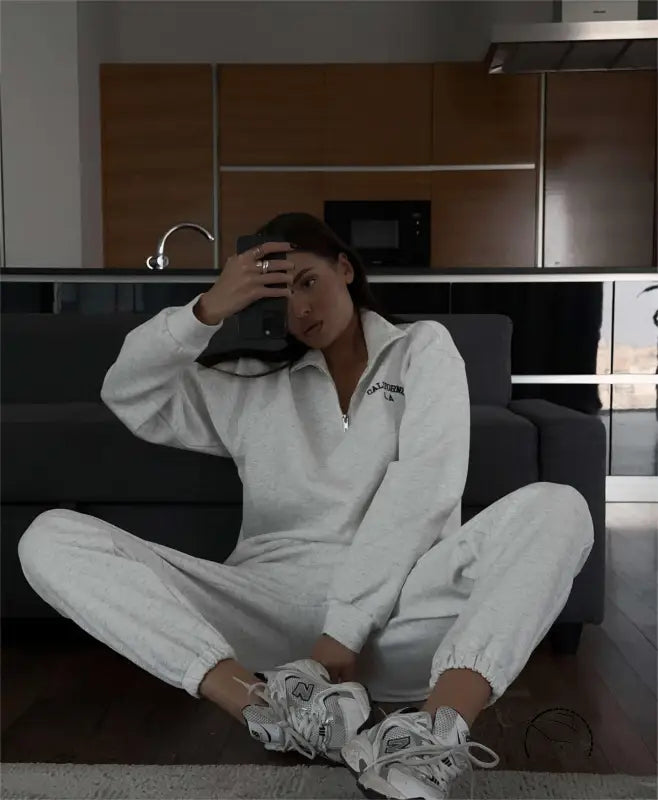 Woman in white tracksuit with autumn winter fleece lined half zipper sweater