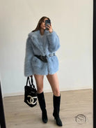 Light blue fluffy faux fur coat with black belt and Chanel bag