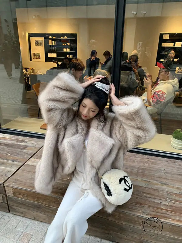 Winter faux fur jacket in white and gray tones with plush texture and Chanel logo