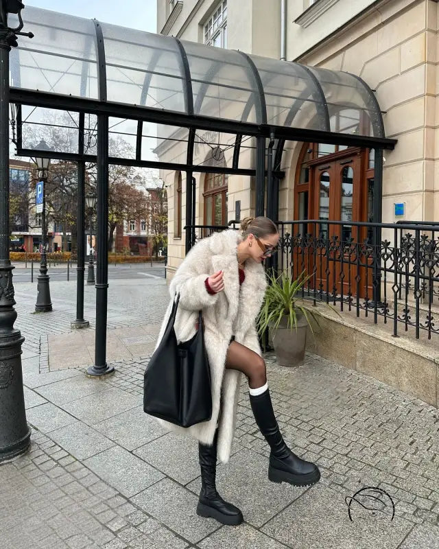 Warm winter faux fur coat with black leather tote and knee-high boots